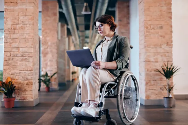 a woman in a wheelchair working on her laptop