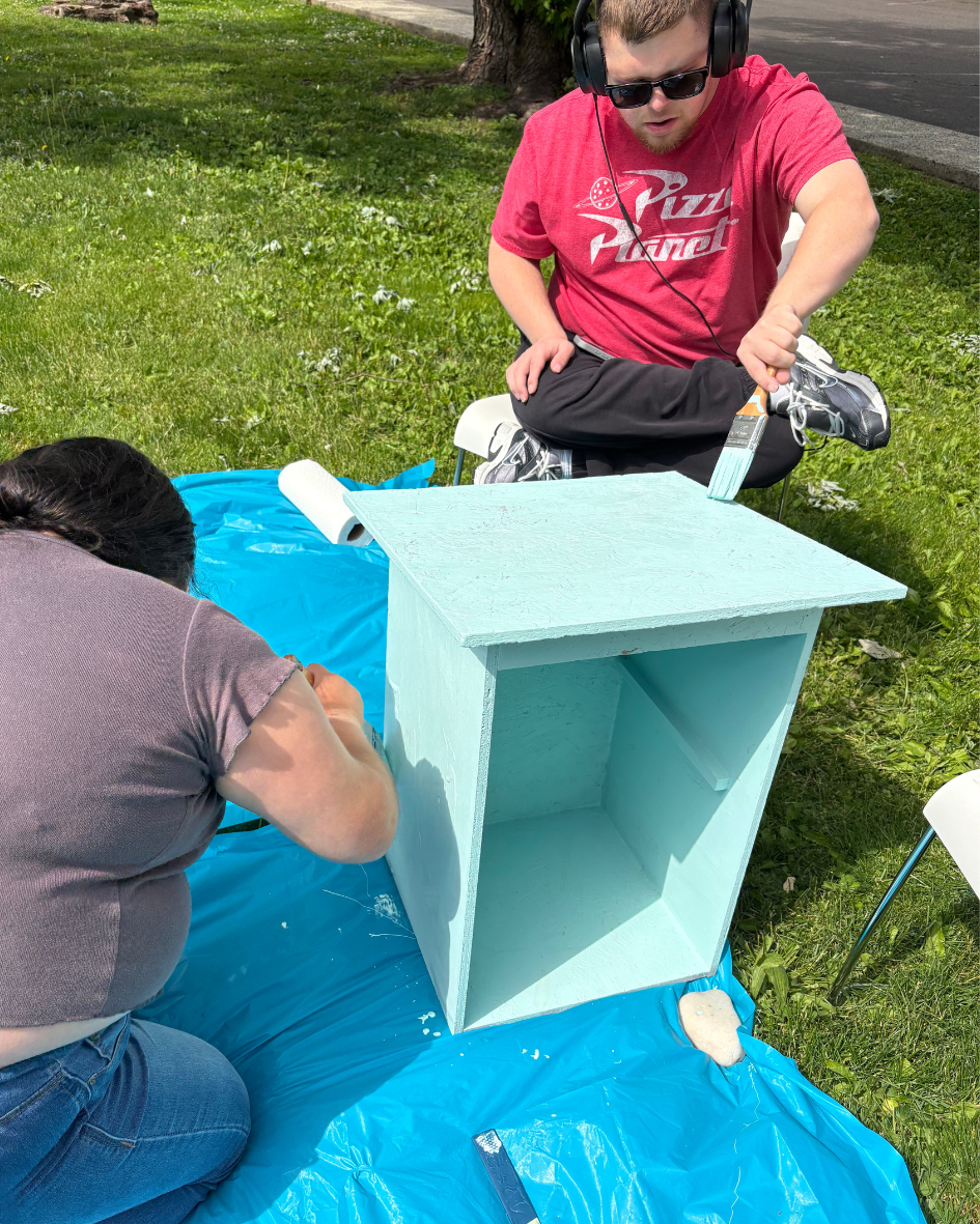 Henry painting the roof of the little library